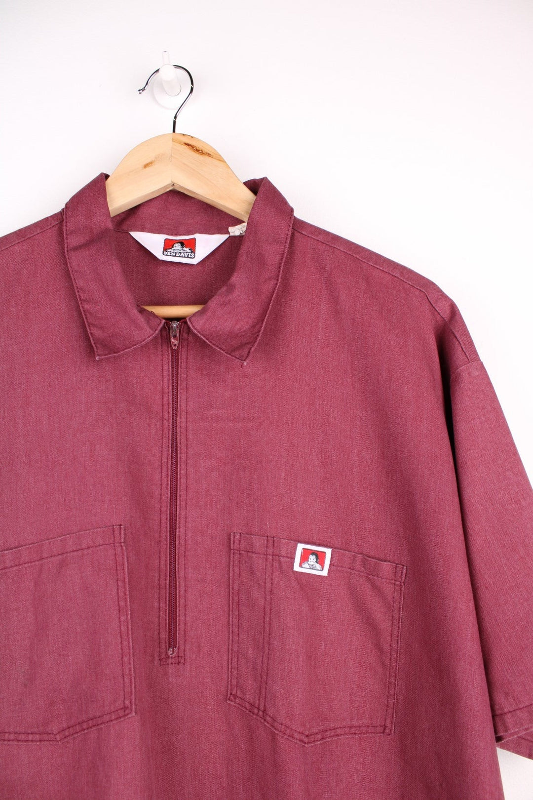  Work Wear Shirt in a burgundy  colourway, zip up half way, has double chest pockets with the logo embroidered on.