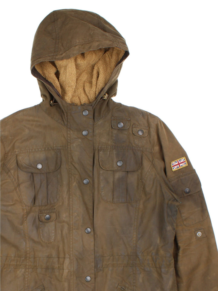 Barbour Winter Force Parka Jacket in a green colourway, zips up and buttons up, has multiple pockets, hooded, insulated with a sherpa lining, and has the logo embroidered on the front.