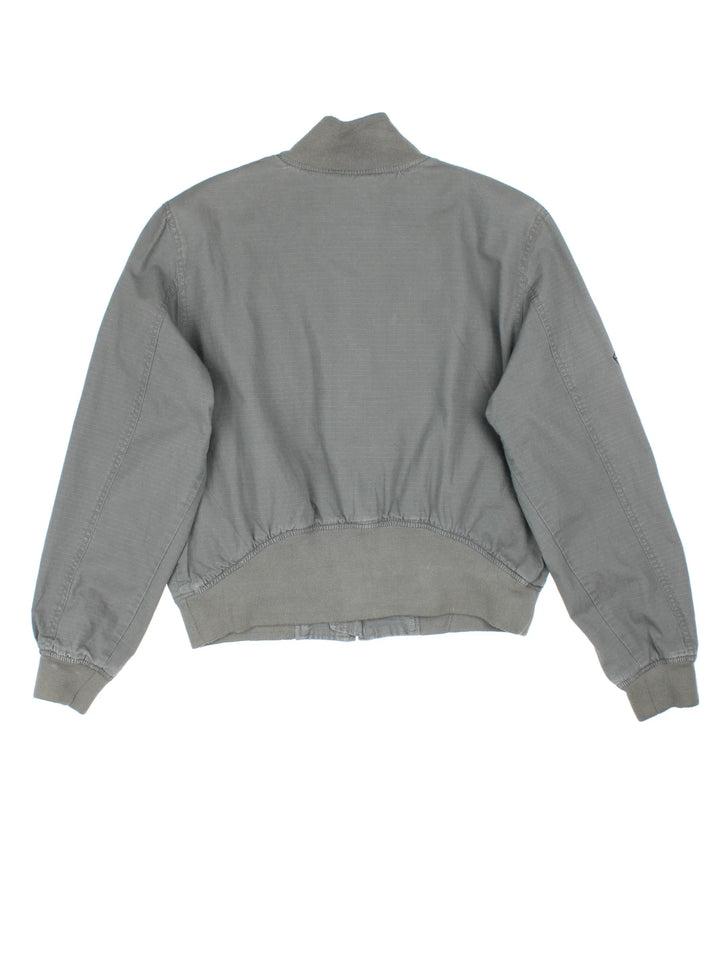 Harley-Davidson Bomber Jacket in a grey colourway. Zips up and has multiple pockets, and the logo embroidered on the front and right sleeve.