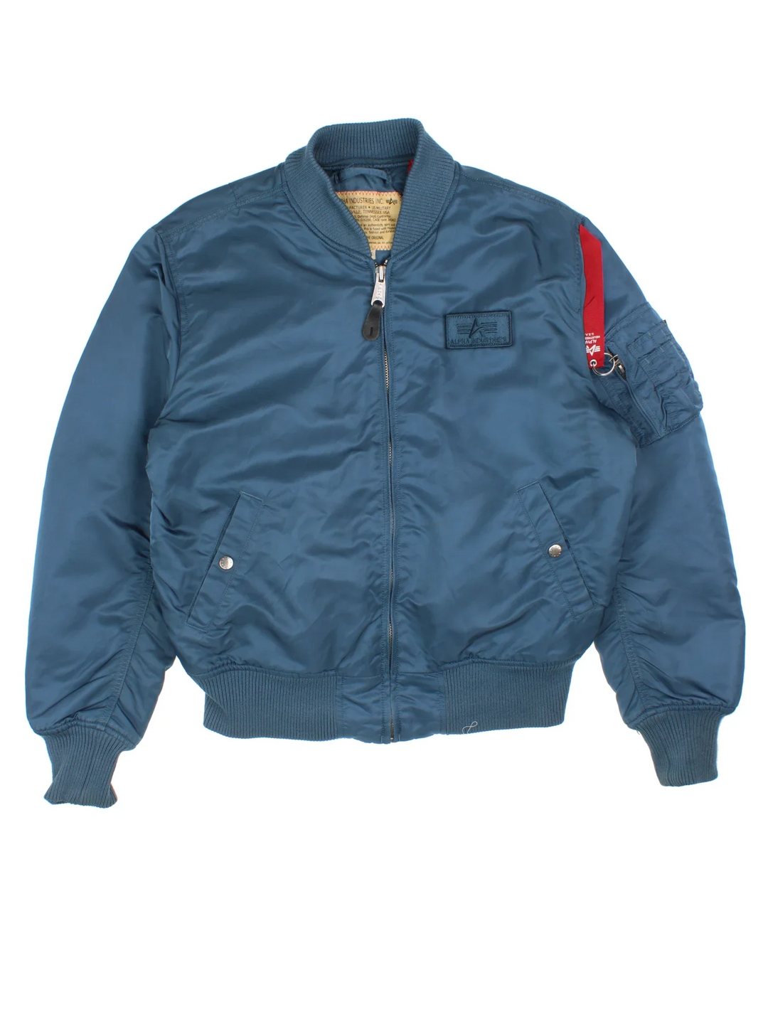 Alpha Industries Bomber Jacket in a blue colourway. Zips up and has multiple pockets, insulated with a quilted lining, and has velcro patch logo on the front.