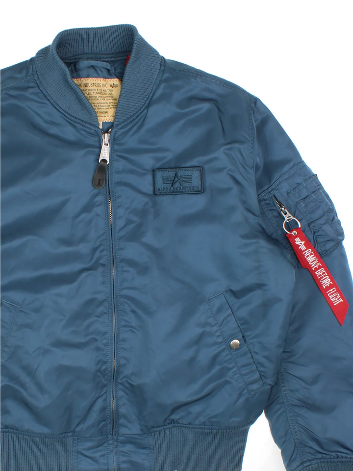 Alpha Industries Bomber Jacket in a blue colourway. Zips up and has multiple pockets, insulated with a quilted lining, and has velcro patch logo on the front.
