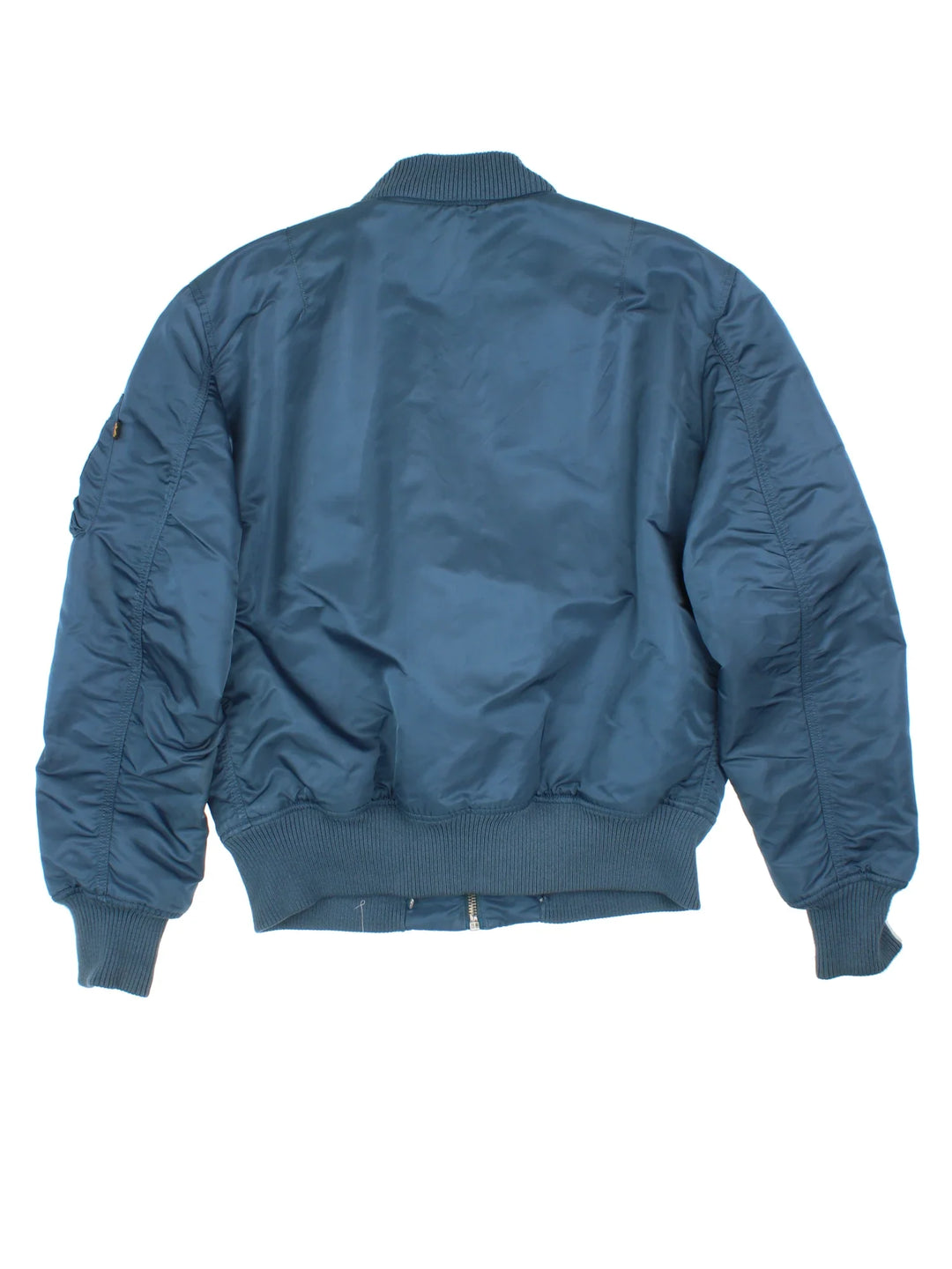 Alpha Industries Bomber Jacket in a blue colourway. Zips up and has multiple pockets, insulated with a quilted lining, and has velcro patch logo on the front.