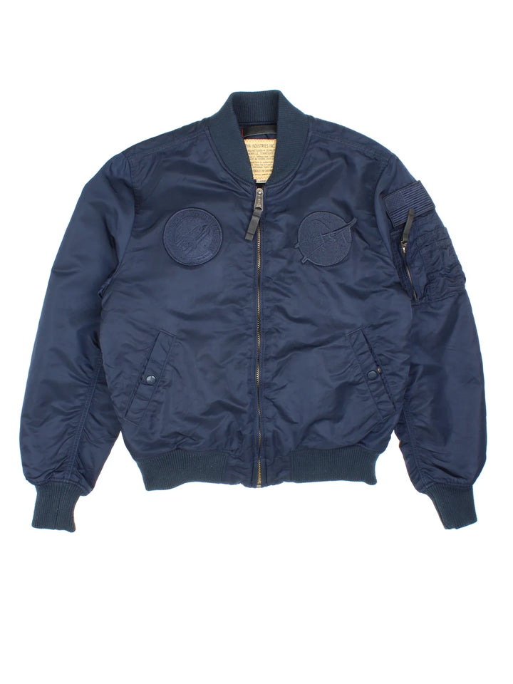 Alpha Industries NASA Bomber Jacket in a blue colourway. Zips up and has multiple pockets, insulated lining, and has the logo embroidered on the front and left sleeve.