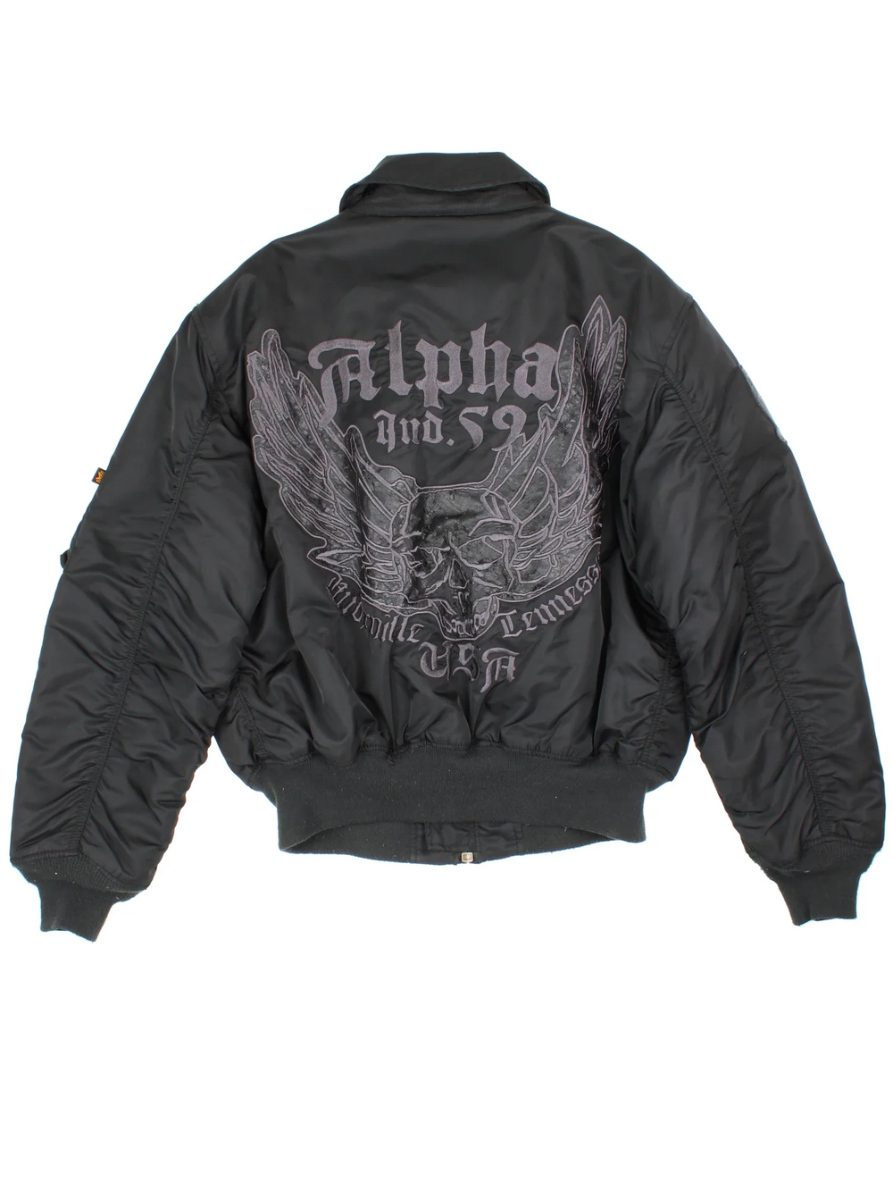 Alpha Industries Embroidered Skull Bomber Jacket in a black colourway. Zips up and has multiple pockets, insulated lining, and has the logo embroidered on the front/sleeve and on the back a big skull graphic embroidered alongside spell out.