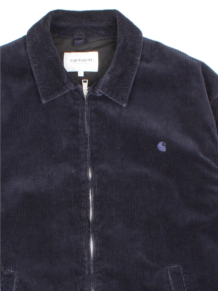 Carhartt Corduroy Jacket in a blue colourway. Zips up and has side pockets, and the logo embroidered on the front.