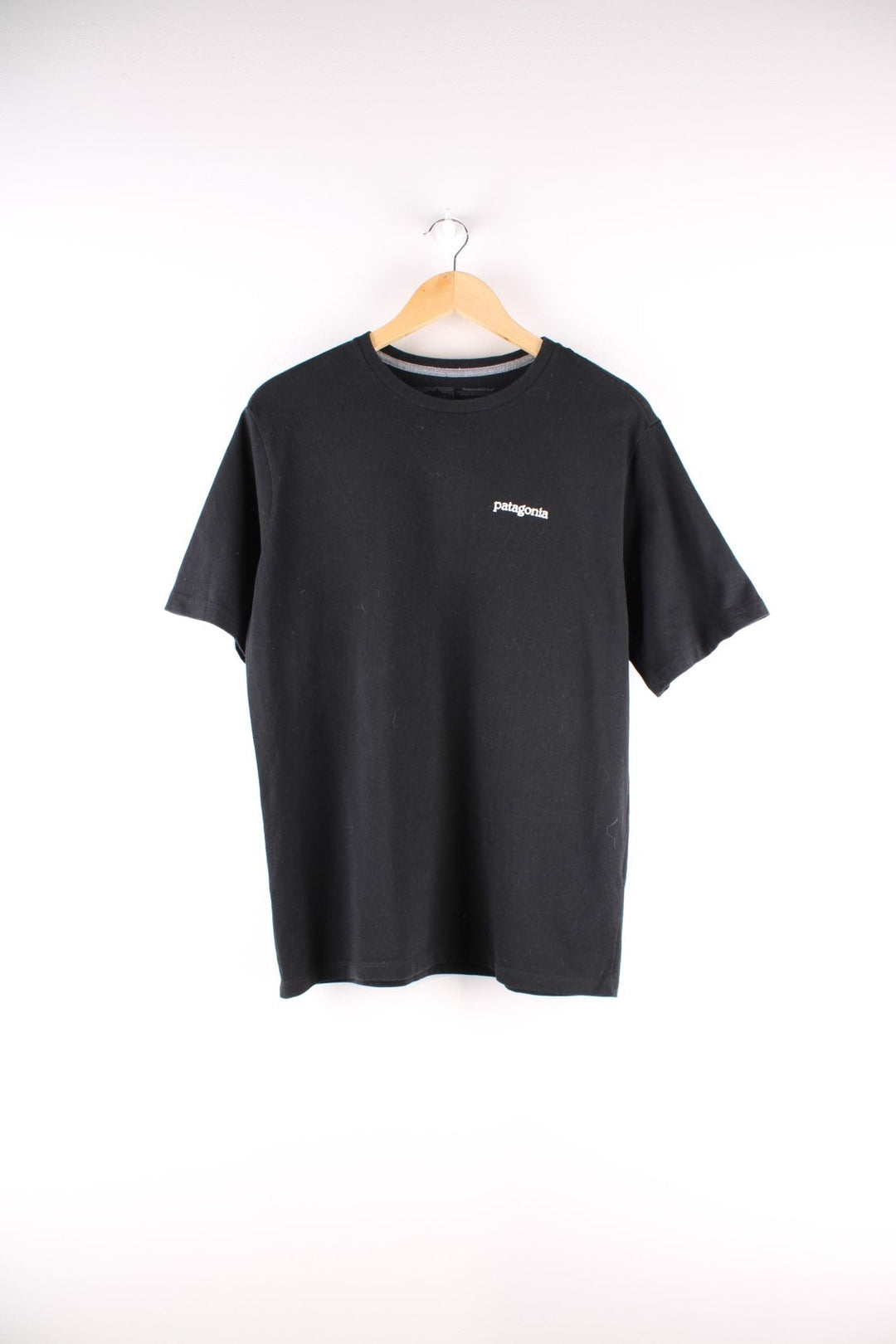 Patagonia t-shirt in black with a small spellout in white on the front, and a logo graphic on the back.