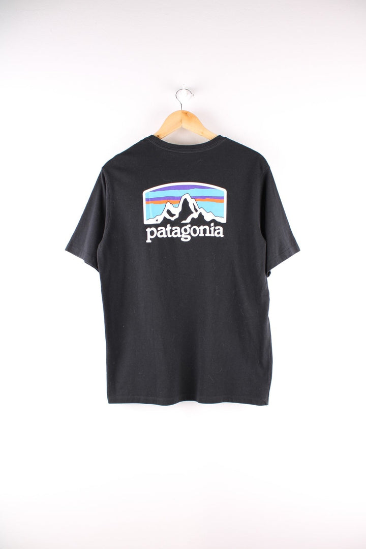 Patagonia t-shirt in black with a small spellout in white on the front, and a logo graphic on the back.