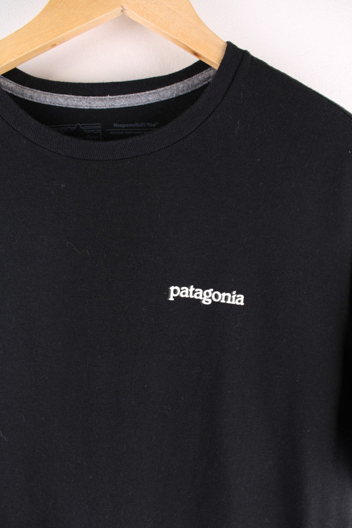 Patagonia t-shirt in black with a small spellout in white on the front, and a logo graphic on the back.