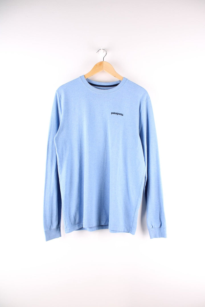 Patagonia long sleeved t-shirt in a blue with a small spellout on the front and a large mountain logo on the back.