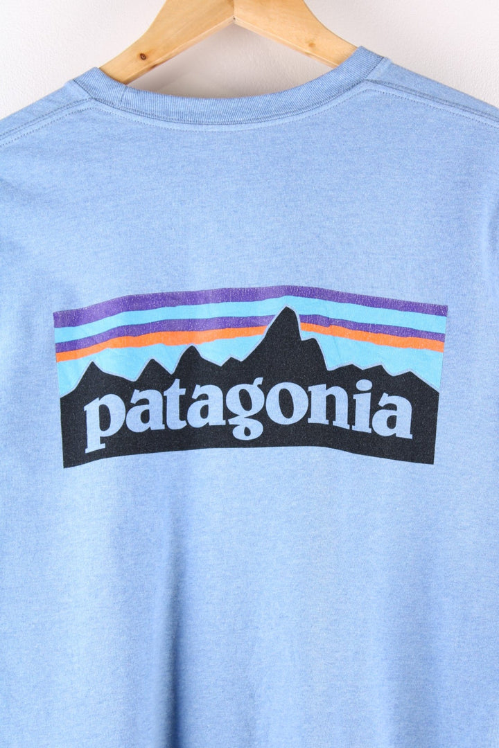 Patagonia long sleeved t-shirt in a blue with a small spellout on the front and a large mountain logo on the back.
