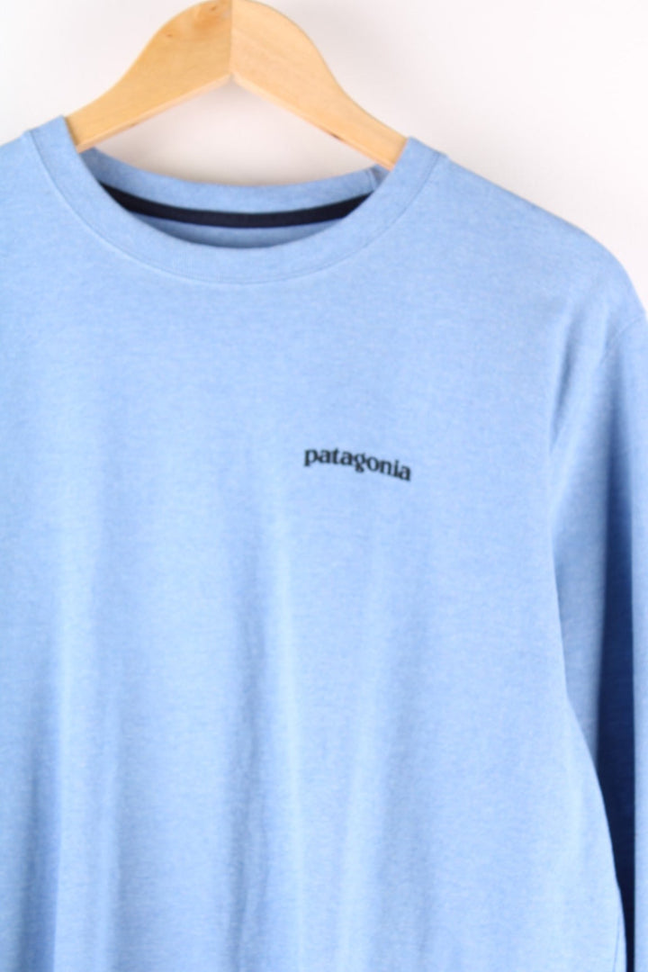 Patagonia long sleeved t-shirt in a blue with a small spellout on the front and a large mountain logo on the back.