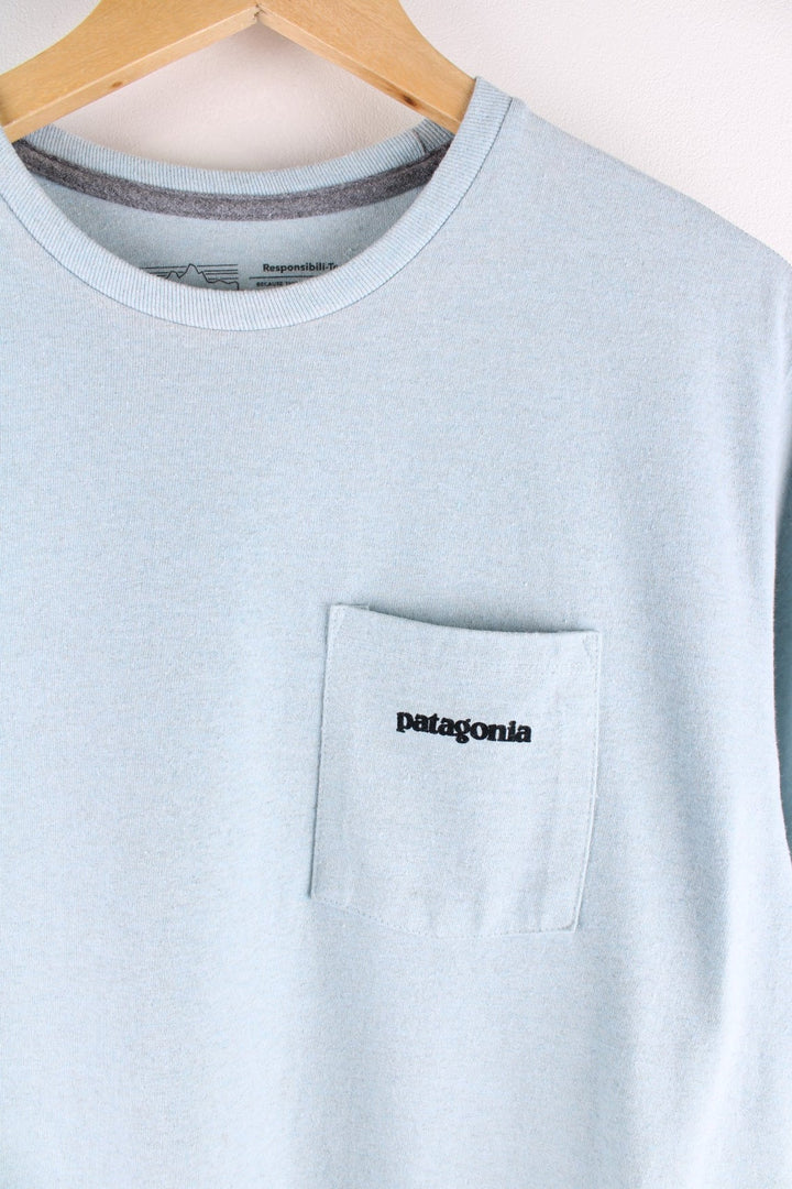 Patagonia t-shirt in blue with a chest pocket and small spellout printed on the front and large mountain logo on the back.