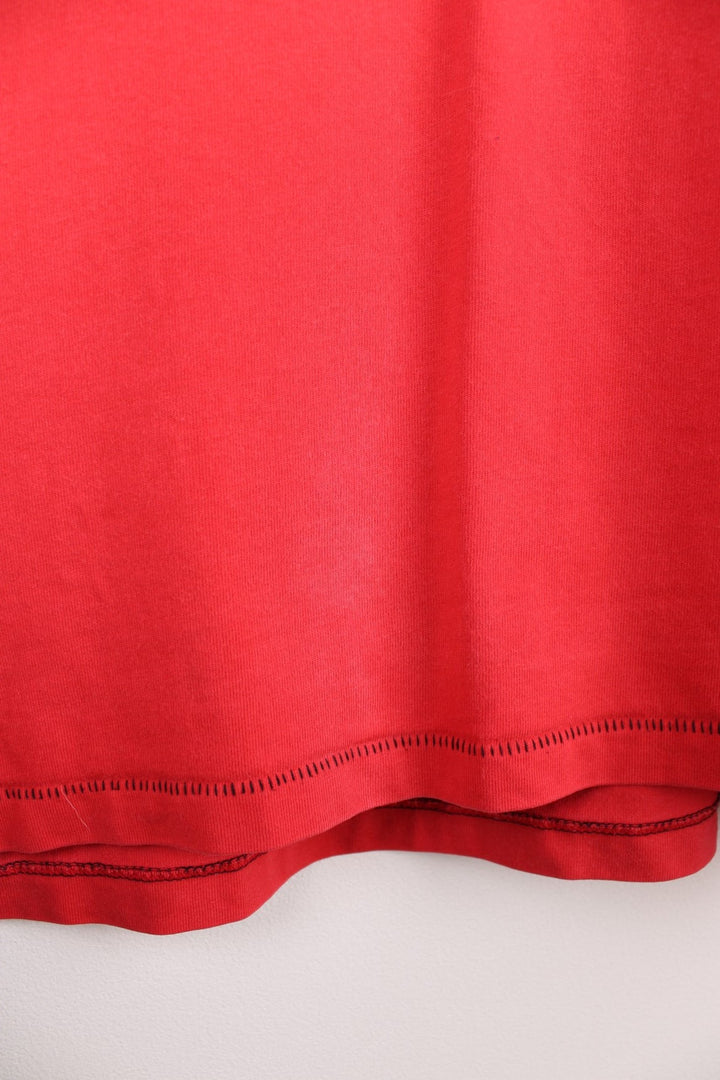Adidas Rugby T-Shirt in a red and black colourway with the spell out logo and globe graphic printed on the front, and badge logos embroidered on the sleeves. 