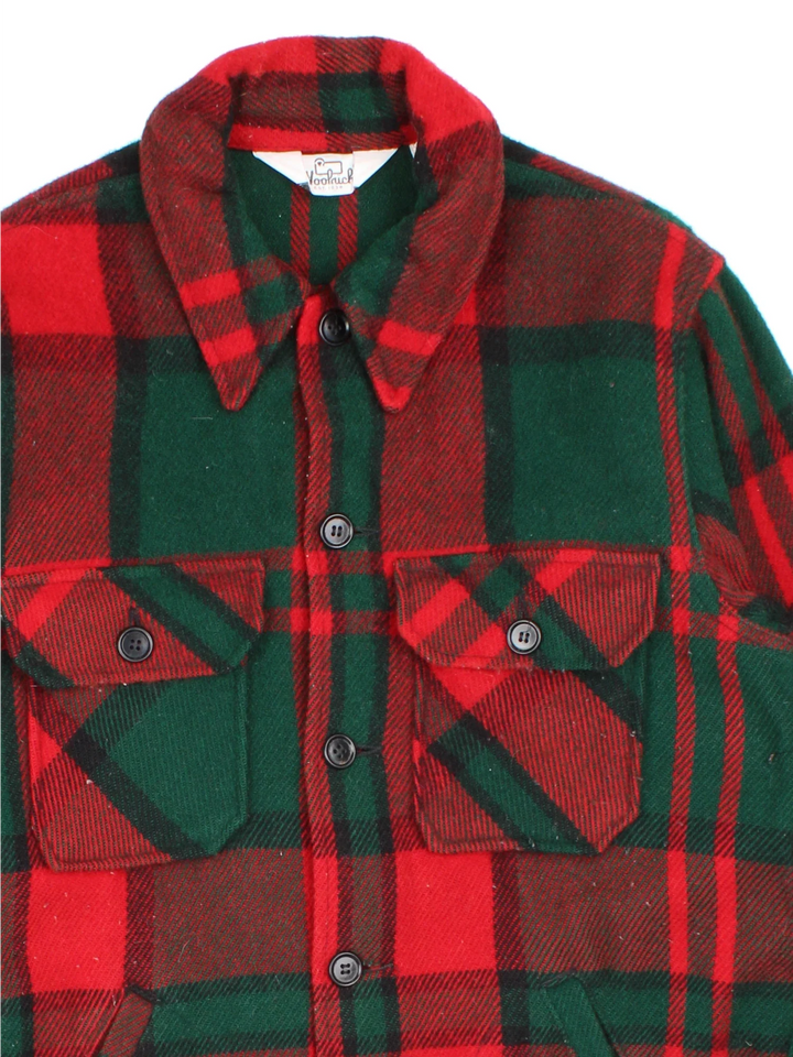 Woolrich Woollen Plaid lannel CPO Jacket in a red and green colourway. Buttons up and has multiple pockets, and all over plaid pattern.