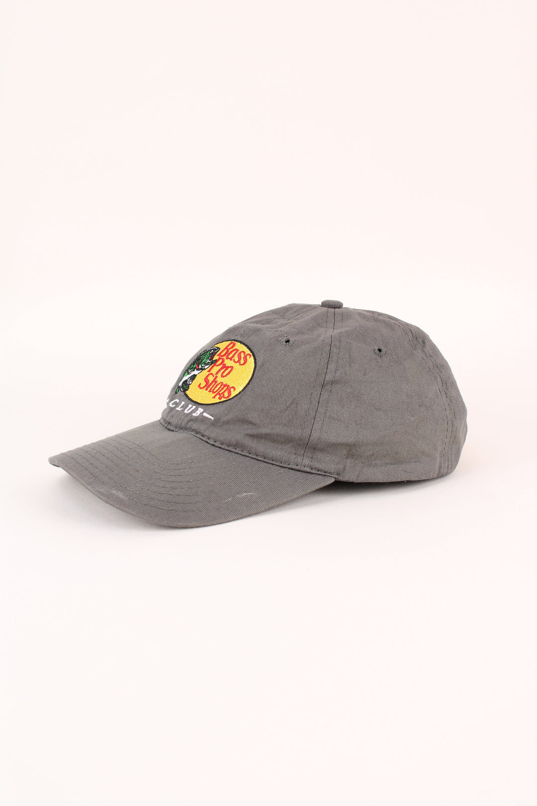 Vintage Bass Pro Shops Club Cap in a grey colourway with the logo embroidered on the front, and has adjustable strap on the back.