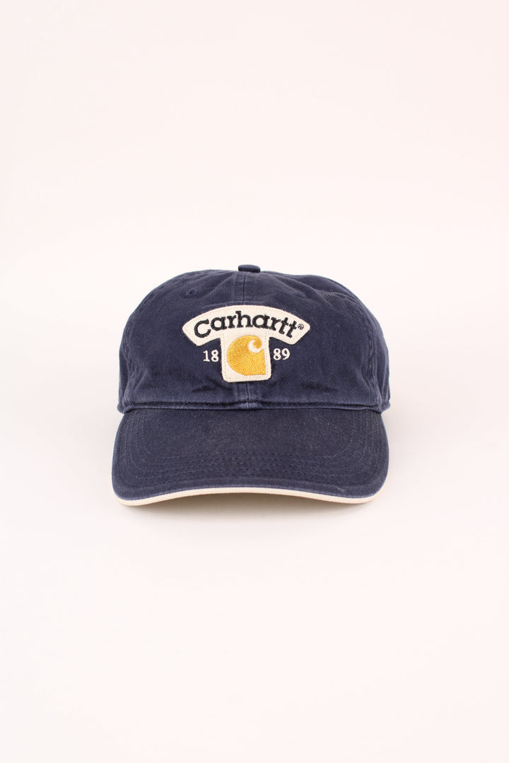 Carhartt 1989 Cap in a blue colourway with the logo embroidered on the front, and has adjustable velcro strap at the back.