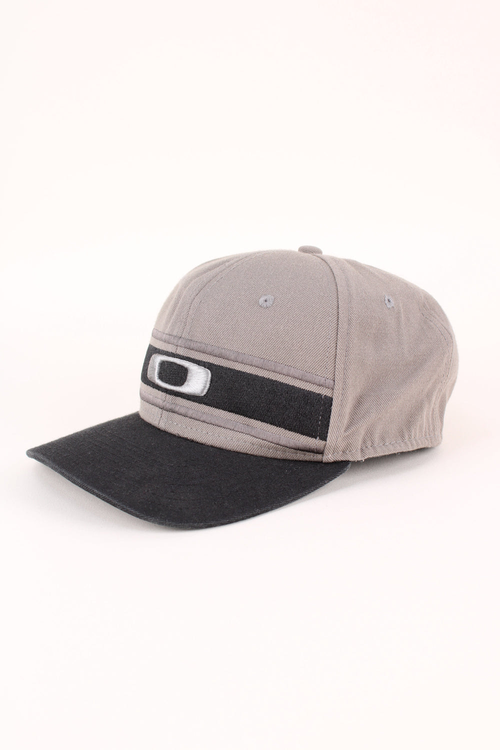 Oakley Snapback in a grey and black colourway with the logo embroidered on the front, and has adjustable velcro snapback.