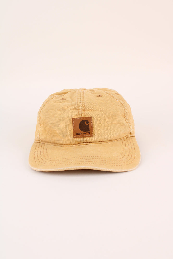 Carhartt Cap in a tan colourway with the logo embroidered on the front, and has adjustable velcro strap at the back.