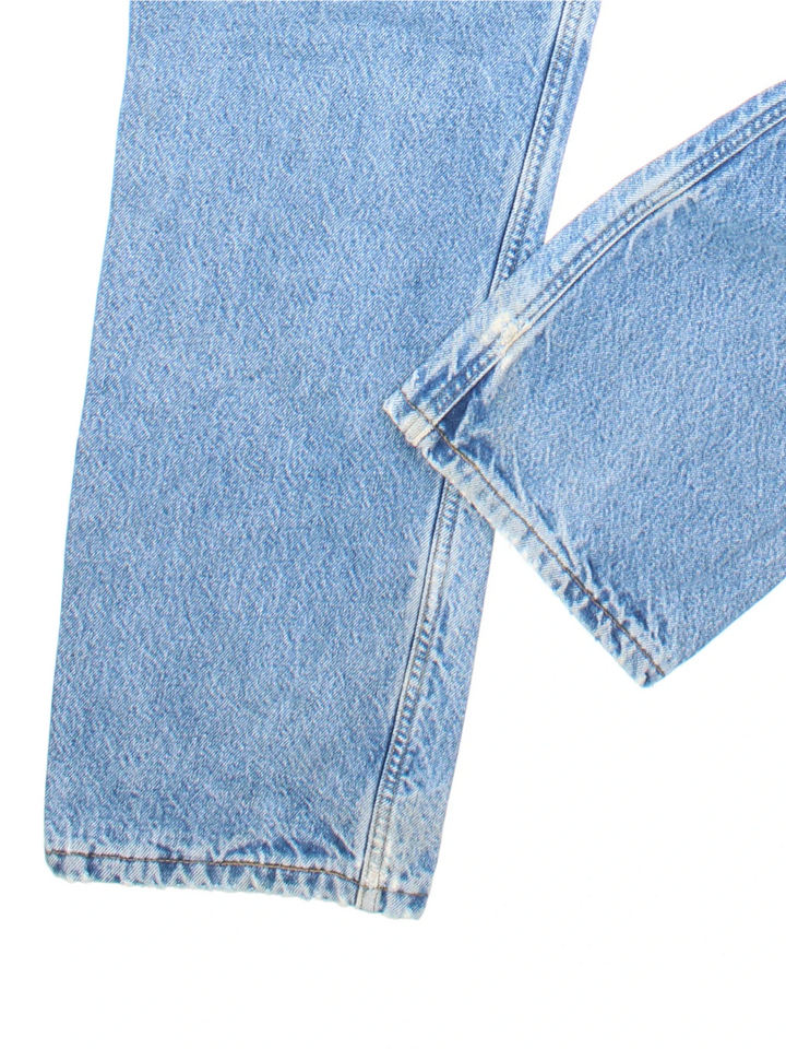 Carhartt Jeans in a blue colourway with multiple pockets, tartan lining, and the logo embroidered on the back.