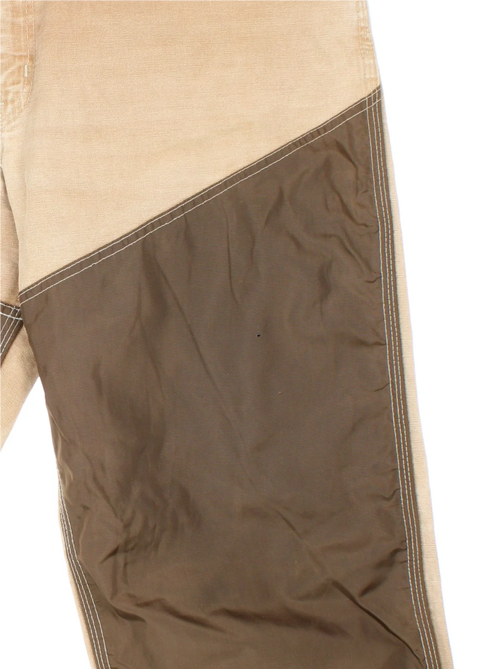 Carhartt Workwear Jeans in a tan and brown colourway with multiple pockets and the logo embroidered on the back.