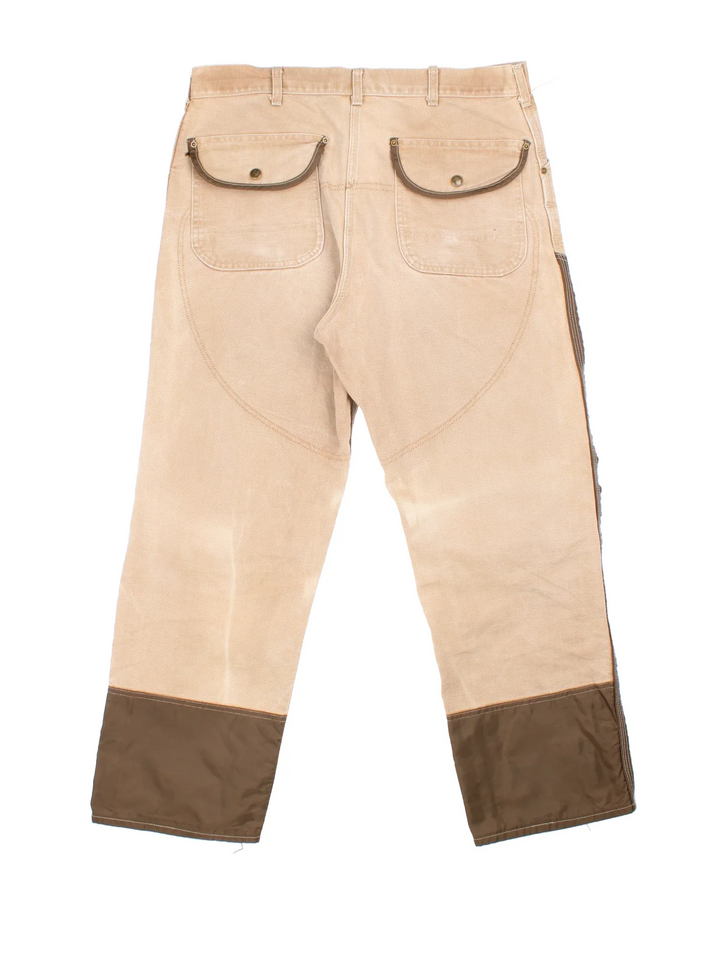 Carhartt Workwear Jeans in a tan and brown colourway with multiple pockets and the logo embroidered on the back.