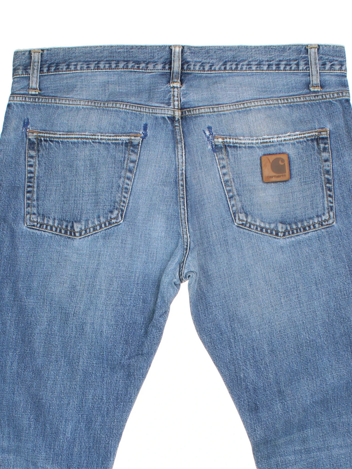 Carhartt Jeans in a blue colourway with multiple pockets and the logo embroidered on the back.