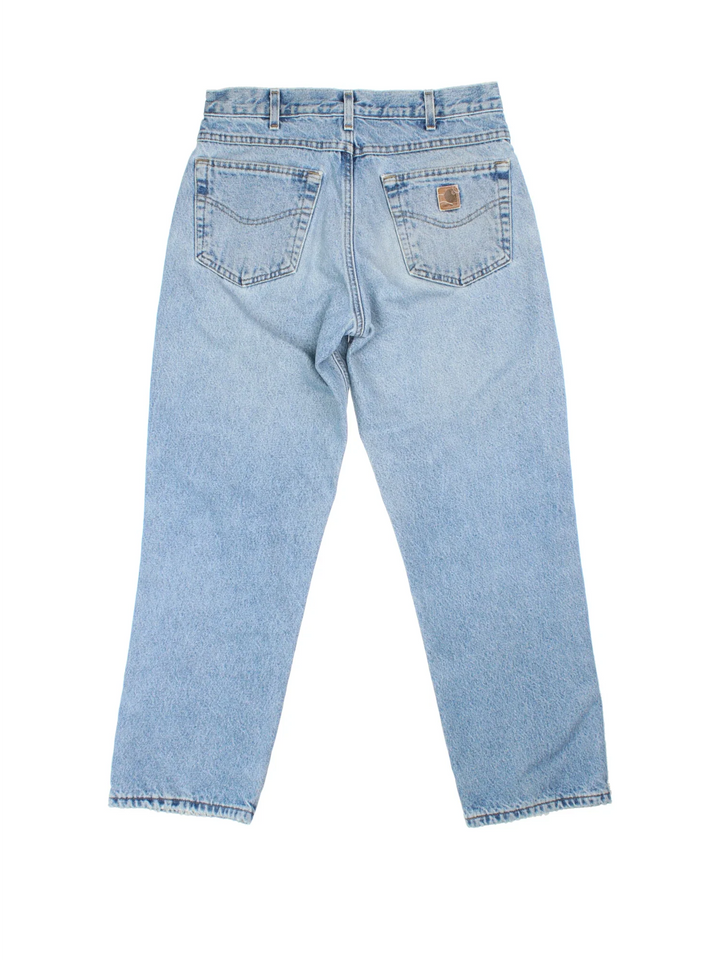 Carhartt Jeans in a blue colourway with multiple pockets, plaid pattern lining, and the logo embroidered on the back.