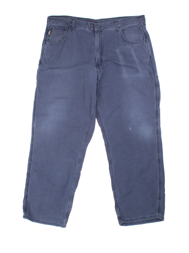 Carhartt Carpenter Trousers in a blue colourway with multiple pockets and the logo embroidered on the back.