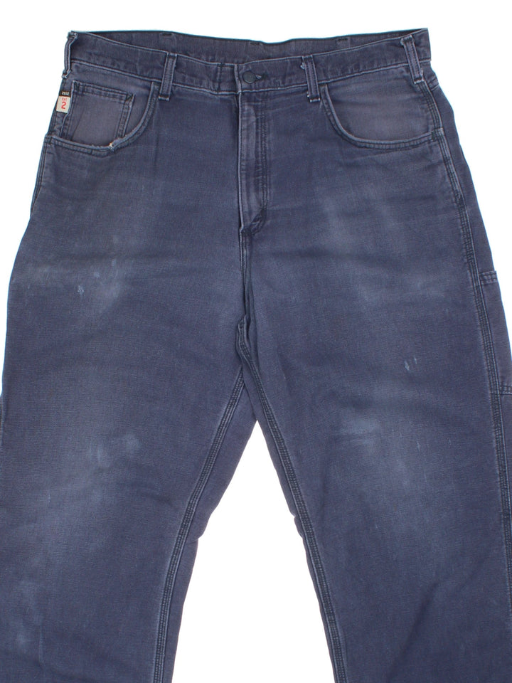 Carhartt Carpenter Trousers in a blue colourway with multiple pockets and the logo embroidered on the back.