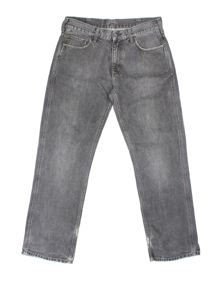 Carhartt Jeans in a grey colourway with multiple pockets and the logo embroidered on the back.
