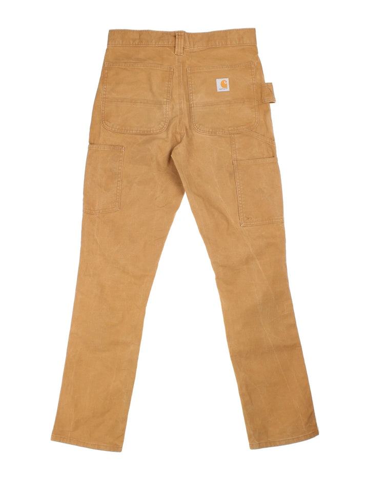 Carhartt Double Knee Jeans in a tan colourway with multiple pockets and the logo embroidered on the back.