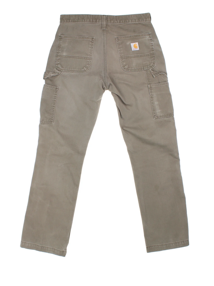 Carhartt Carpenter Trousers in a green colourway with multiple pockets and the logo embroidered on the back.