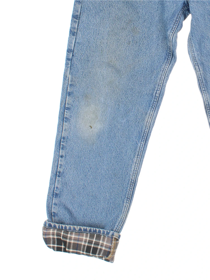 Carhartt Jeans in a blue colourway with multiple pockets, checked lining and the logo embroidered on the back.