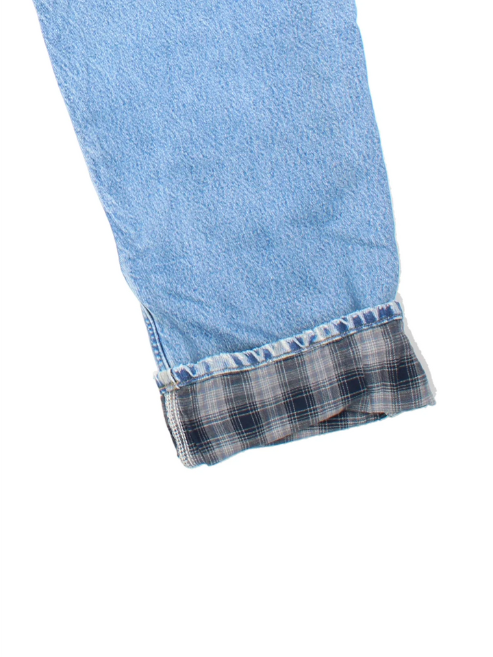 Carhartt Jeans in a blue colourway with multiple pockets, plaid pattern lining and the logo embroidered on the back.