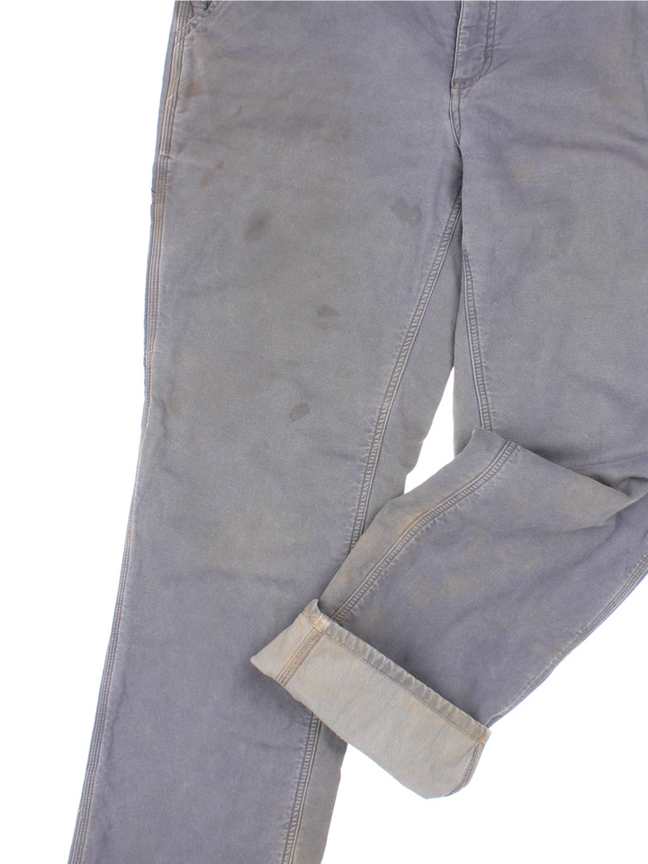 Carhartt Fleece Lined Carpenter Jeans in a grey colourway with multiple pockets and the logo embroidered on the back.