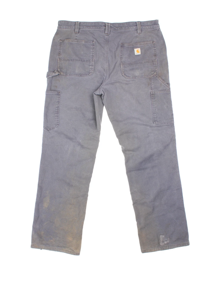 Carhartt Fleece Lined Carpenter Jeans in a grey colourway with multiple pockets and the logo embroidered on the back.