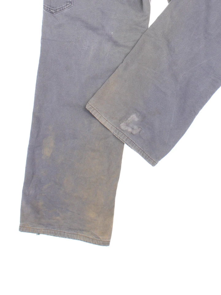 Carhartt Fleece Lined Carpenter Jeans in a grey colourway with multiple pockets and the logo embroidered on the back.