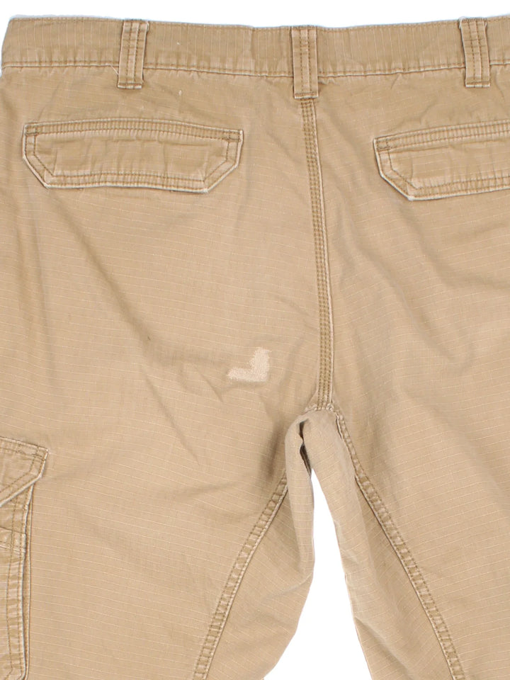 Carhartt Cargo Trousers in a tan colourway with multiple pockets and the logo embroidered on the back.