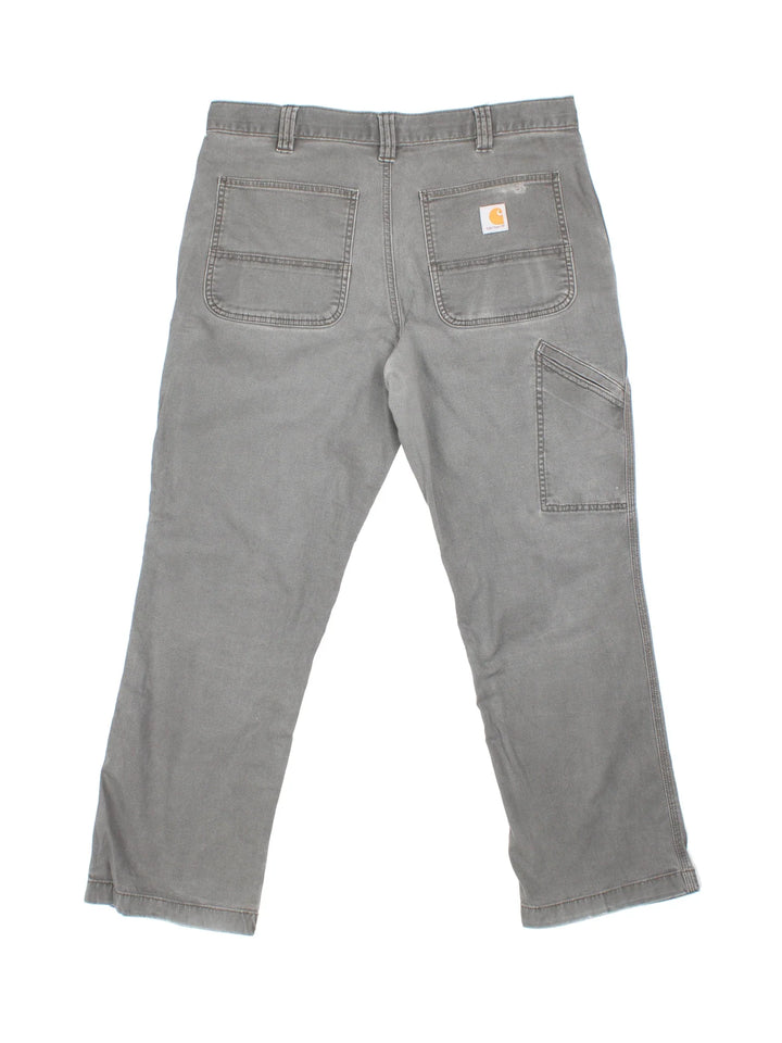 Carhartt Trousers in a grey colourway with multiple pockets and the logo embroidered on the back.