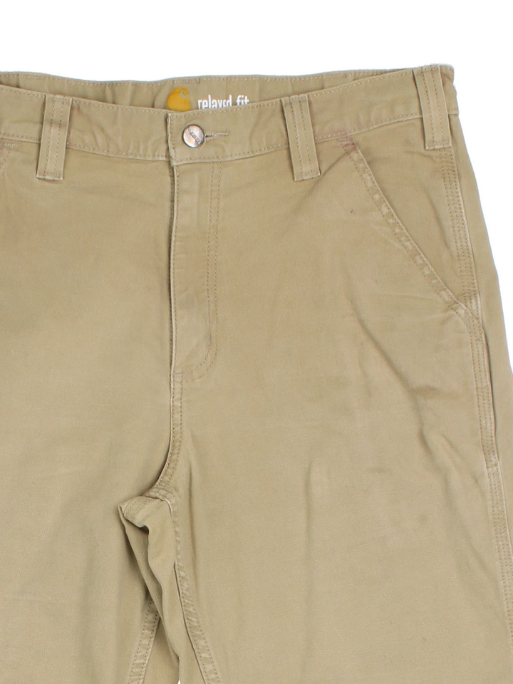 Carhartt Trousers in a tan colourway with multiple pockets and the logo embroidered on the back.