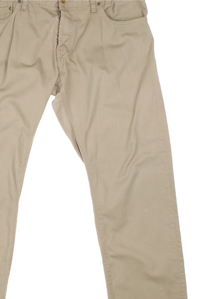 Carhartt Jeans in a tan colourway with multiple pockets and the logo embroidered on the back.