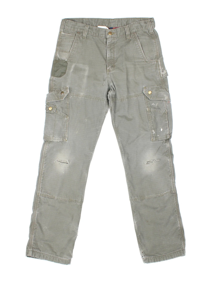Carhartt Lined Cargo Trousers in a green colourway with multiple pockets, checked lining and the logo embroidered on the back.