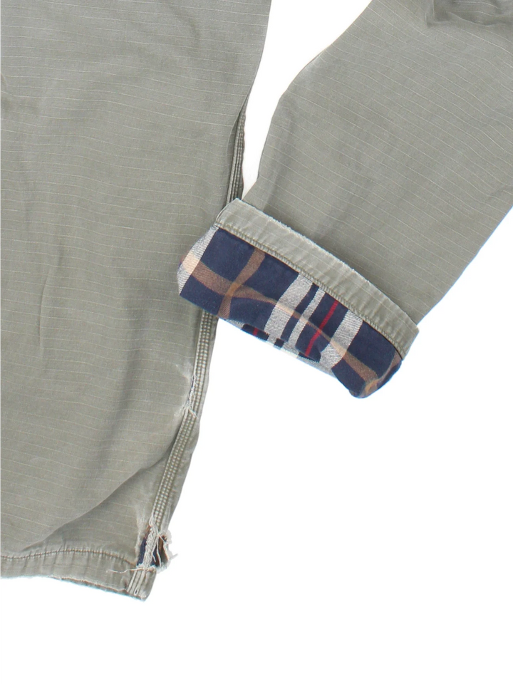 Carhartt Lined Cargo Trousers in a green colourway with multiple pockets, checked lining and the logo embroidered on the back.