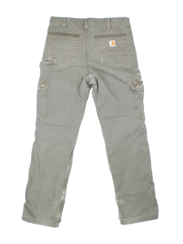 Carhartt Lined Cargo Trousers in a green colourway with multiple pockets, checked lining and the logo embroidered on the back.