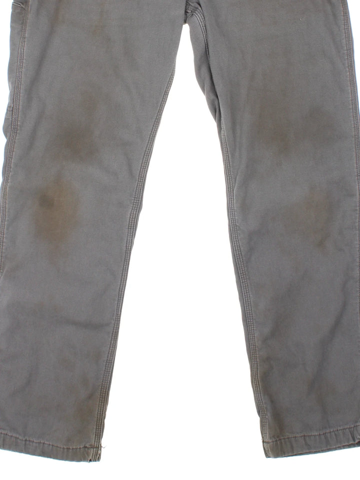 Carhartt Carpenter Trousers in a grey colourway with multiple pockets and the logo embroidered on the back.