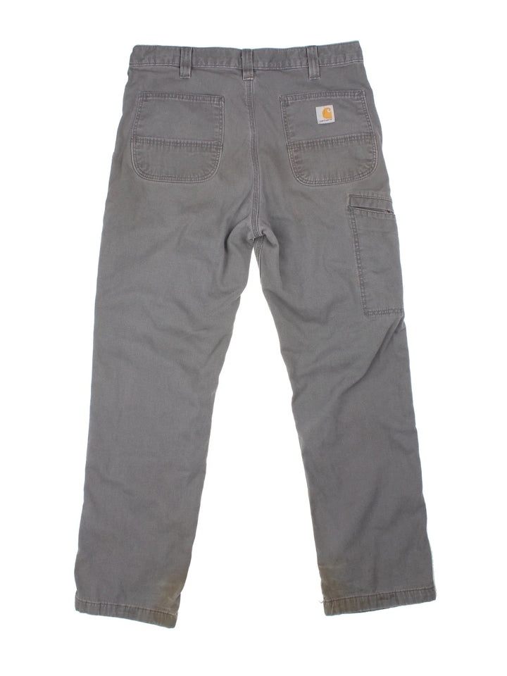 Carhartt Carpenter Trousers in a grey colourway with multiple pockets and the logo embroidered on the back.