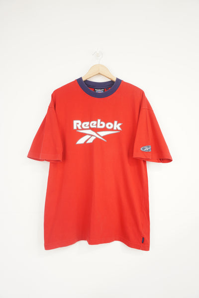 Vintage red and blue Reebok tee with spell-out graphic on the front and tab on the sleeve