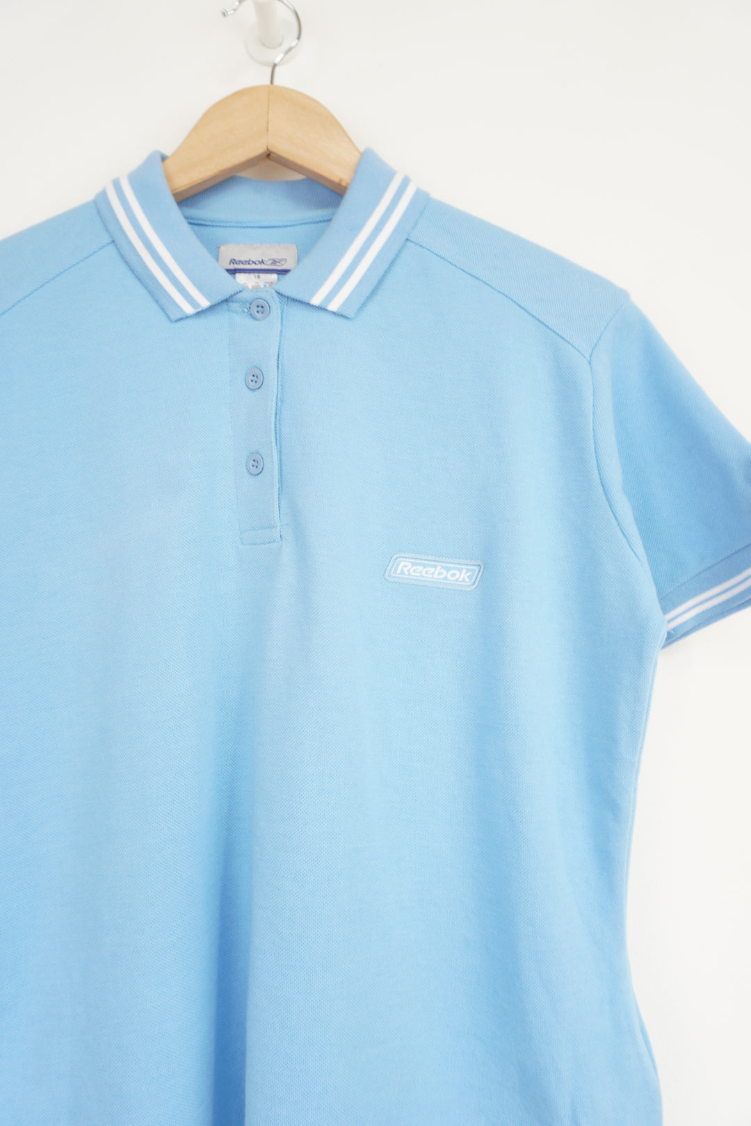Baby blue Reebok polo shirt with embroidered logo on the chest