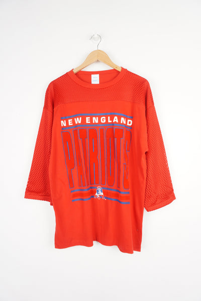 Red 3/4 length sleeve t-shirt with net jersey style detail over the arms and shoulders. Features Printed NFL New England Patriots graphic on the front with red flocking on the 'Patriots'.  good condition
