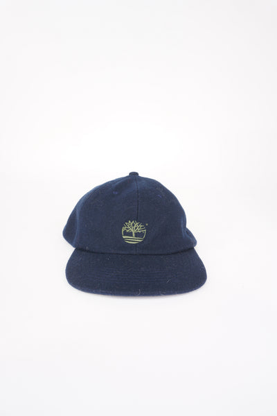Navy blue wool baseball cap with embroidered green Timberland logo and adjustable strap. Good condition 